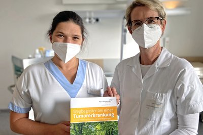 OÄ Dr.in Daniela Voskova und Stationsleiterin DGKP Christine Gegenleitner mit der Info-Broschüre für Patientinnen und Patienten mit einer Tumorerkrankung und deren Angehörige. 