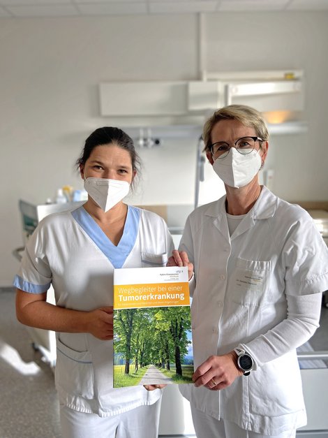 OÄ Dr.in Daniela Voskova und Stationsleiterin DGKP Christine Gegenleitner mit der Info-Broschüre für Patientinnen und Patienten mit einer Tumorerkrankung und deren Angehörige. 
