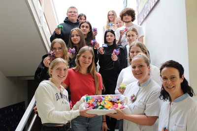 Gruppenbild auf Stiege mit Korb voll Filz-Schmetterlingen in der Hand
