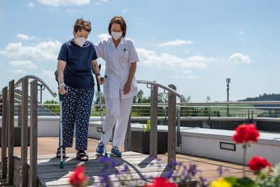 Pflegerin mit Patientin im Garten