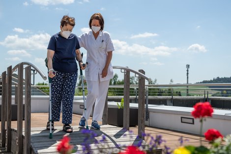 Pflegerin mit Patientin im Garten