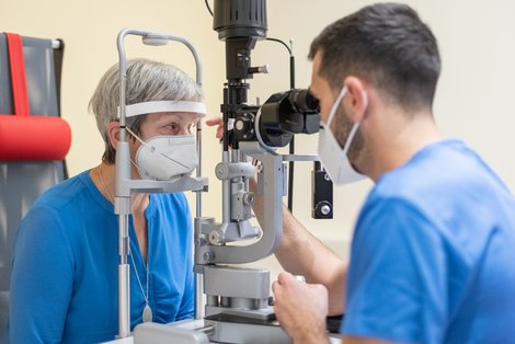 Arzt untersucht Augen einer Patientin