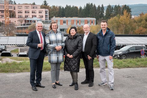 Gruppenfoto vor PV-Anlage und Baustelle