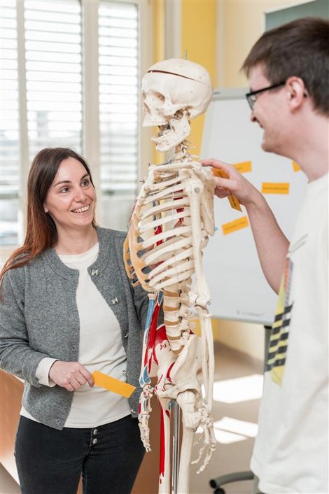 Pflegeschüler mit Plastikskelett