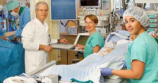3 Mitarbeiter an einem Intensivbett