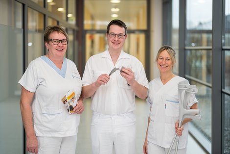 Arzt, Pflegekraft und Physiotherapeutin mit Gelenksprothesen