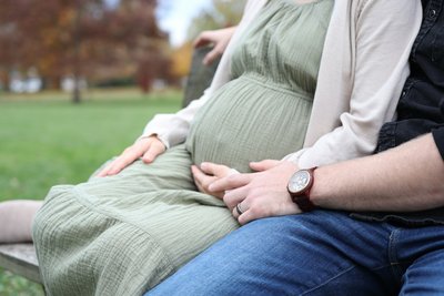 Schwangere, die ihren Bauch hält und Mann daneben