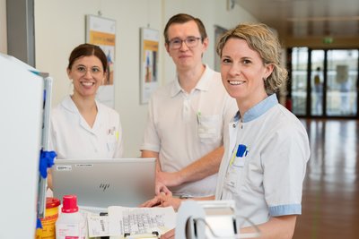 3 MitarbeiterInnen arbeiten gemeinsam am Laptop