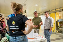 Eine Frau der SHV Schärding unterhält sich am Selbsthilfestand mit Besuchern