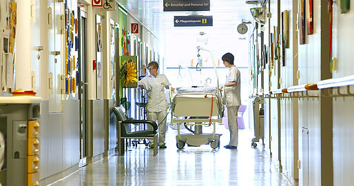 2 Mitarbeiterinnen mit Krankenbett am Gang