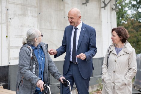 Landesrat Dörfel spricht mit Bewohnerin, daneben steht LAbg. Aspalter