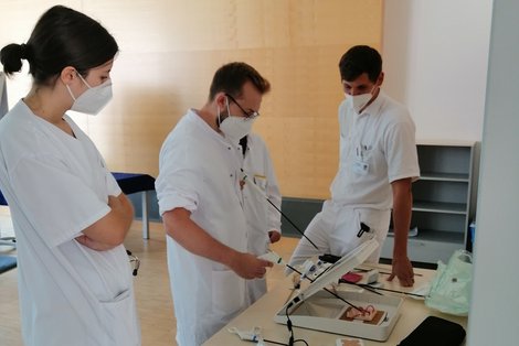 3 Mitglieder der Summer School mit einem Gerät