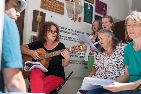 BewohnerInnen des Landespflege- und Betreuungszentrums Schloss Gschwendt singen in Schloss Hartheim die mit der Physio- und Ergotherpie-Leiterin Barbara Perkles (Mi.) einstudierten Lieder zum Gedenken an die damaligen Opfer von Schloss Gschwendt.
