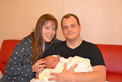 Eltern mit ihrem Neugeborenen in der Hand