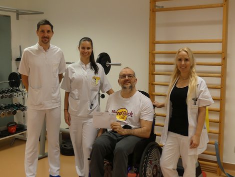 Team der Physio übergibt Spende an Patienten im Rollstuhl
