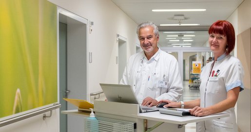Ein Mitarbeiter und eine Mitarbeiterin befinden stehen im Gang