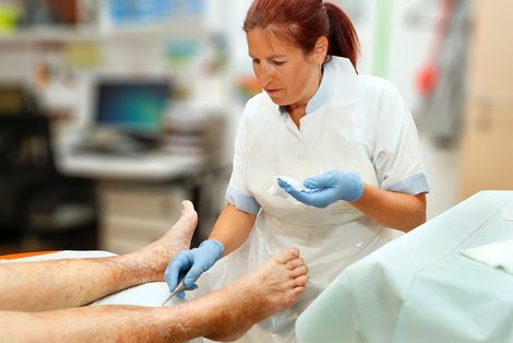 Weibliche Pflegekraft kümmert sich um einen Patienten