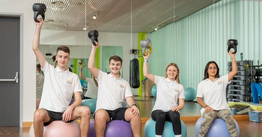 Auszubildende sitzen auf Gymnastikball