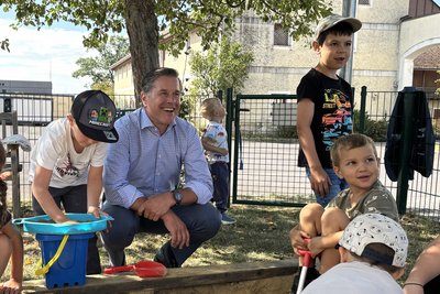 Personaldirektor in Mitten von Kindern in der Kinderbetreuung in der Sandkiste