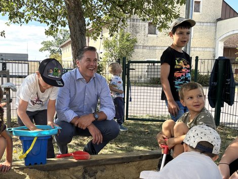 Personaldirektor in Mitten von Kindern in der Kinderbetreuung in der Sandkiste