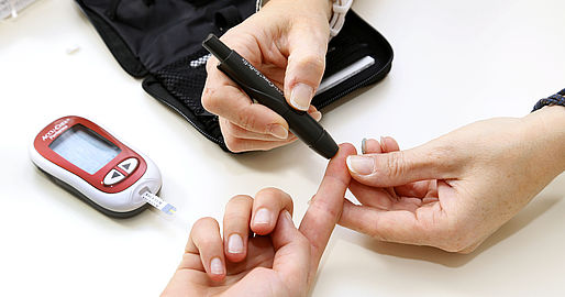 Blutzuckermessung an dem Finger mit Messgerät