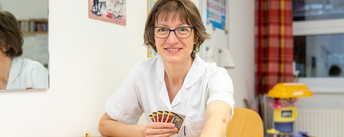 Logopädin spielt ein Brettspiel in der Therapie