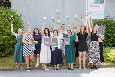 Gruppenfoto der Absolventinnen - alle mit Diplom und Rose in der Hand