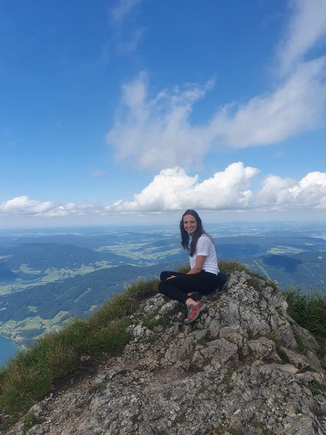 Eva-Maria sitzt auf einem Gipfel eines Bergs