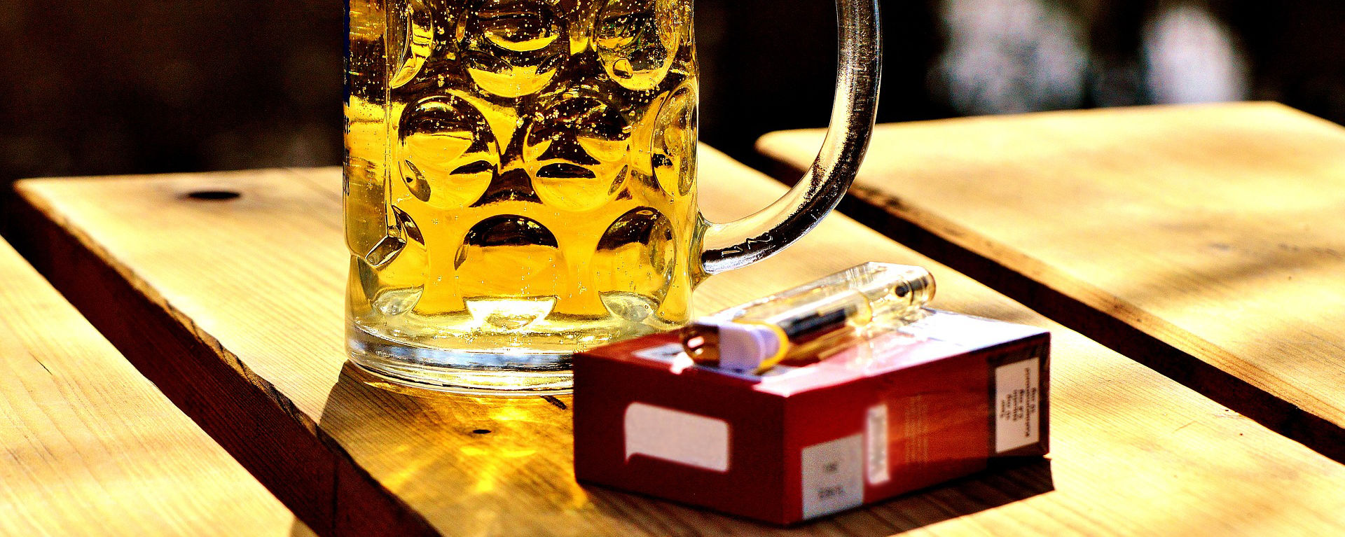 Glas Bier und Zigaretten am Tisch