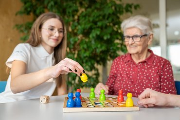 Pflegestarterin bei einem Demenzspiel mit einer Patientin