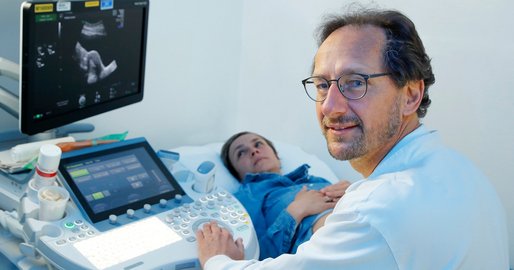 Arzt untersucht eine Patientin mit Ultraschall