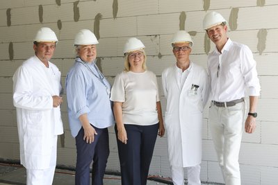 Bild 4: bei der Gleichenfeier stehen mit weißen Helm auf dem Kopf in den Baustellenräumen: von links: Prim. Dr. Martin Barth, DGKP Walpurga Auinger, Mag.a Herta Prandstätter, Prim. Priv.-Doz. Dr. Achim von Goedecke, MSc, Ing. Reinhold Mittermayr.