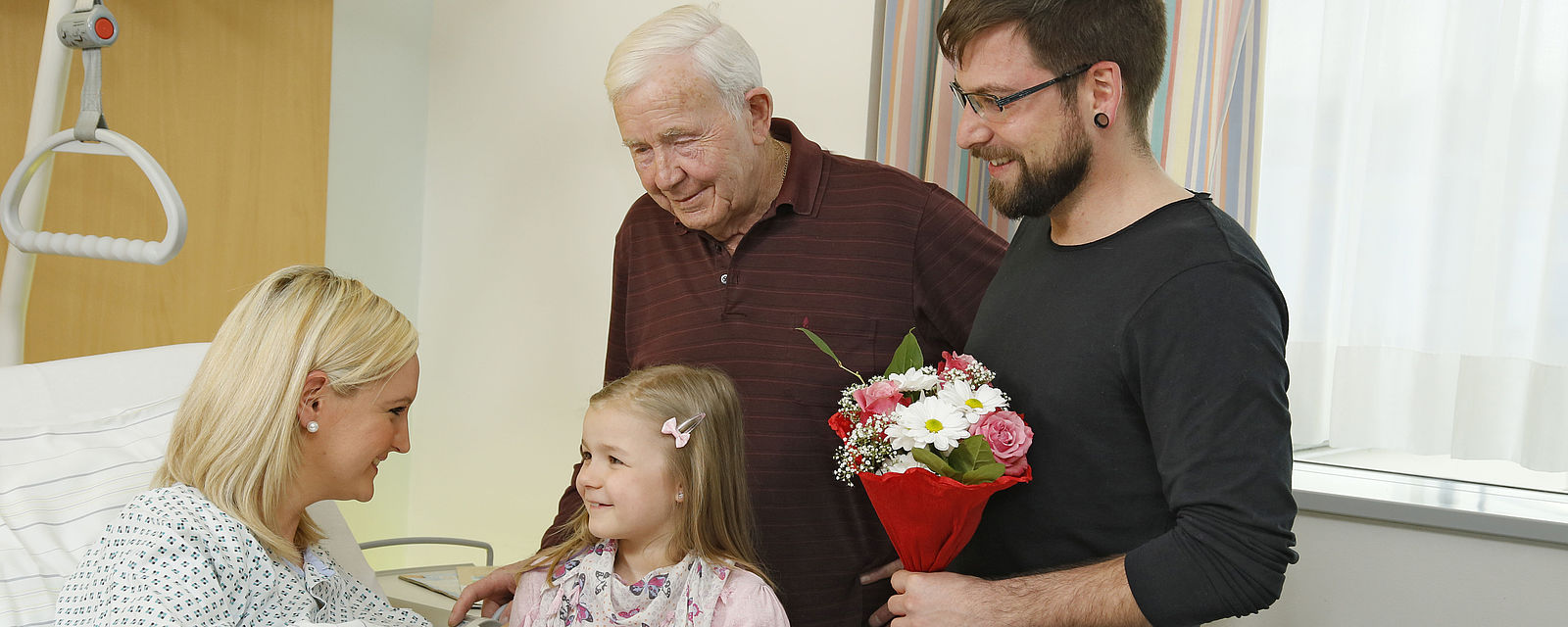 Ein Kind besucht mit Großvater und Vater eine kranke Mutter