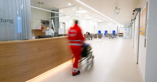 Sanitäter schiebt Rollstuhl in der Notaufnahme