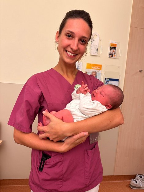 Hebamme Eva-Maria Eckerstorfer mit einem Baby in den Armen