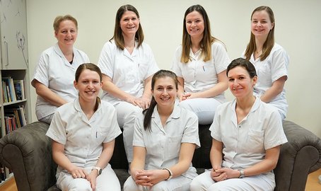 Gruppenfoto der Diätologinnen 3 auf einer braunen Bank sitzend, 4 dahinter stehend