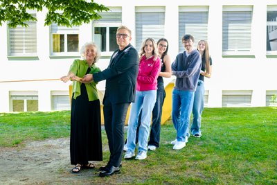 DirektorInnen und SchülerInnen ziehen alle gemeinsam an einem Seil