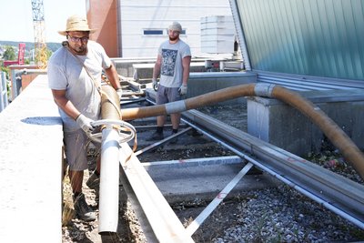Arbeiten entfernen mit großem Saugrohr Kies vom Dach