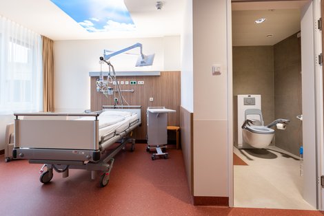 Krankenzimmer mit Bett und Nasszelle