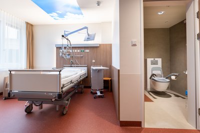 Krankenzimmer mit Bett und Nasszelle