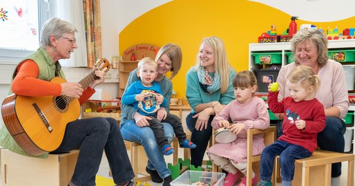 Betreuerinnen musizieren gemeinsam mit den Kindern aus der Kinderbetreuung