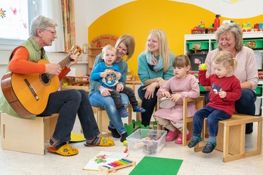 Betreuerinnen musizieren gemeinsam mit den Kindern aus der Kinderbetreuung