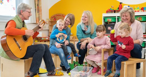 Betreuerinnen musizieren gemeinsam mit den Kindern aus der Kinderbetreuung