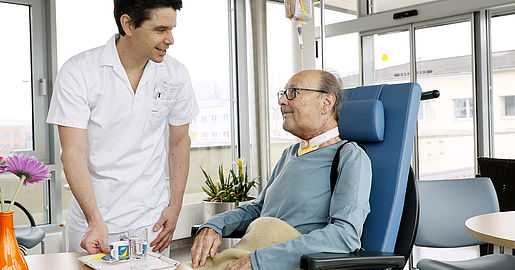 Mitarbeiter bringt Patient einen Kaffee