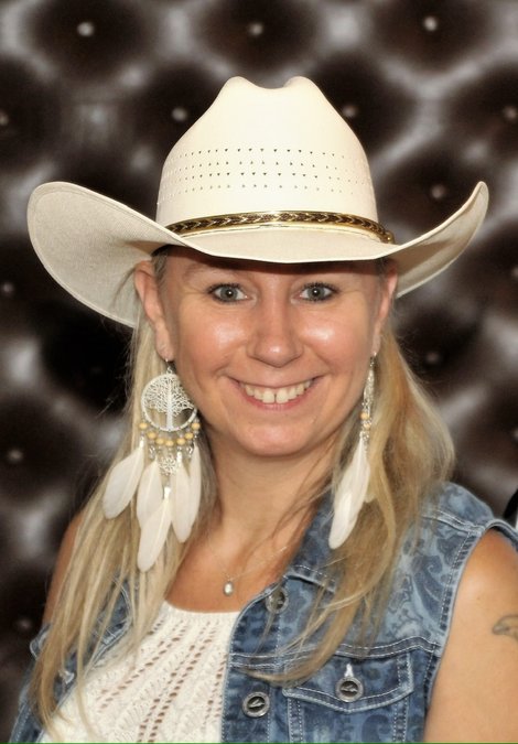 Portrait von Sylvia Hollnsteiner mit Cowboyhut und Federohrringen