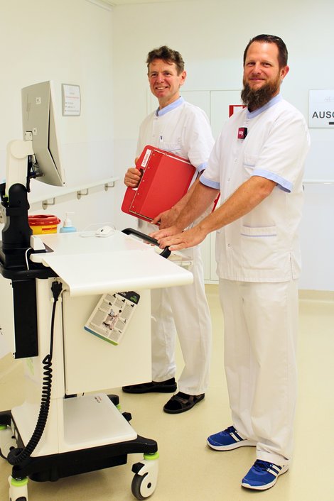 Michael Kerschhofer und ein Kollege besprechen während der Visite die Betreuung von Patientinnen und Patienten.