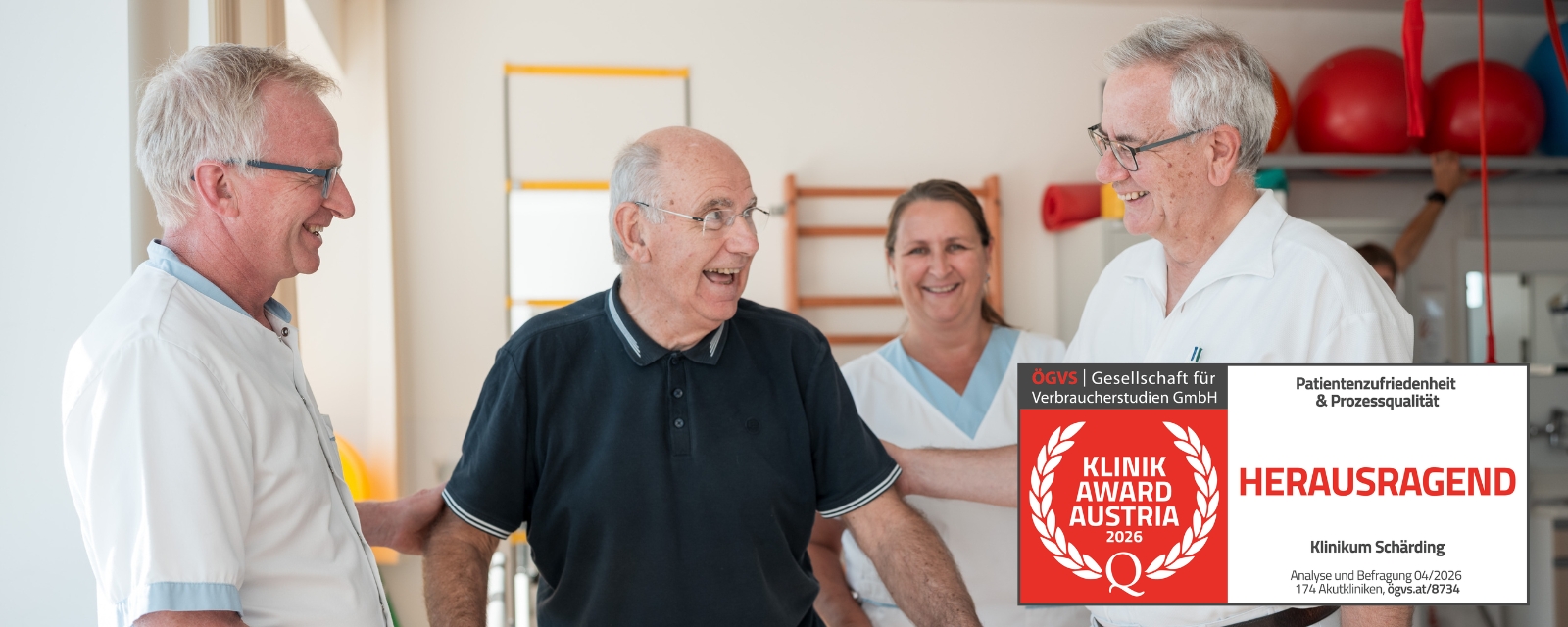 Mehrköpfiges OP‑Team in Schutzkleidung im Operationssaal während einer Vorbereitung; eingeblendete Auszeichnung Klinik Award Austria – Herausragend