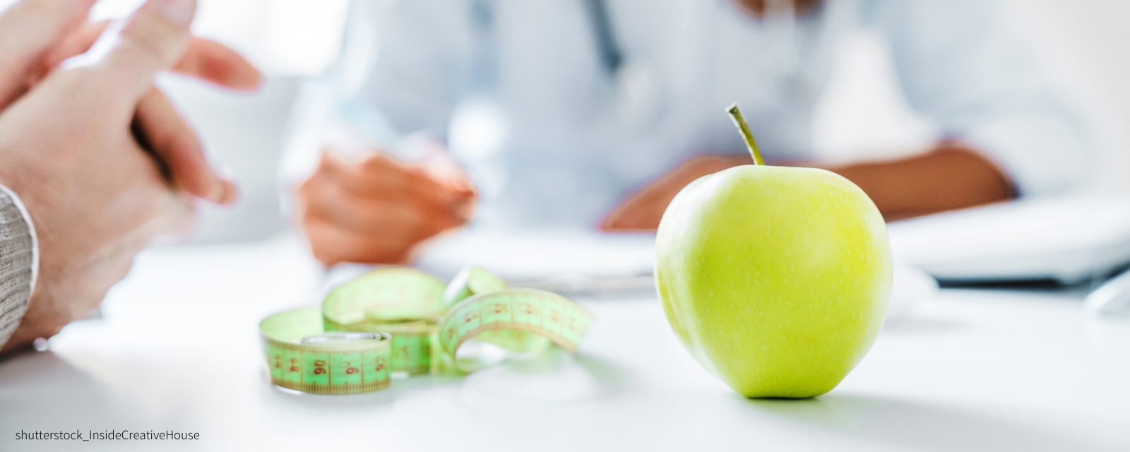 Apfel und Maßband auf einem Tisch