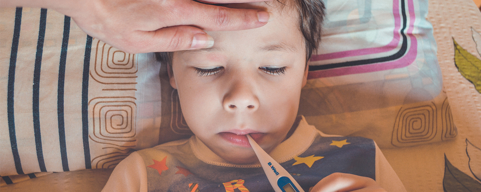 Krankes Kind mit Fieberthermometer im Mund