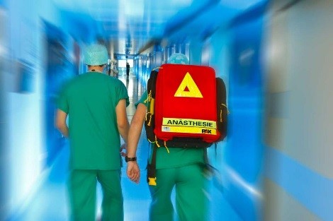 2 Anästhesisten mit Notfalltasche auf dem Weg zum Herzalarm-Patienten